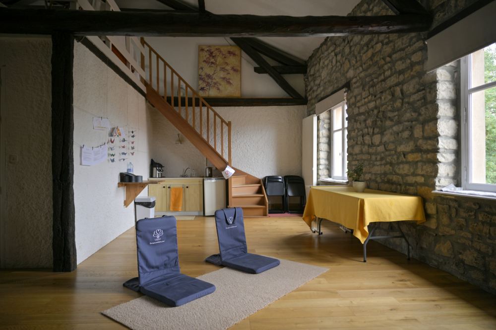 La salle d'activités, ses assises de méditation, l'escalier de bois qui monte à la mezzanine
