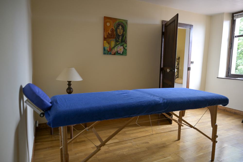 Une salle de soins claire avec une table de massage bleue